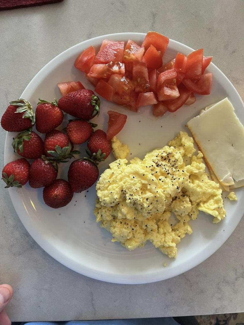 Scrambled eggs with strawberries, tomatoes, and cheese